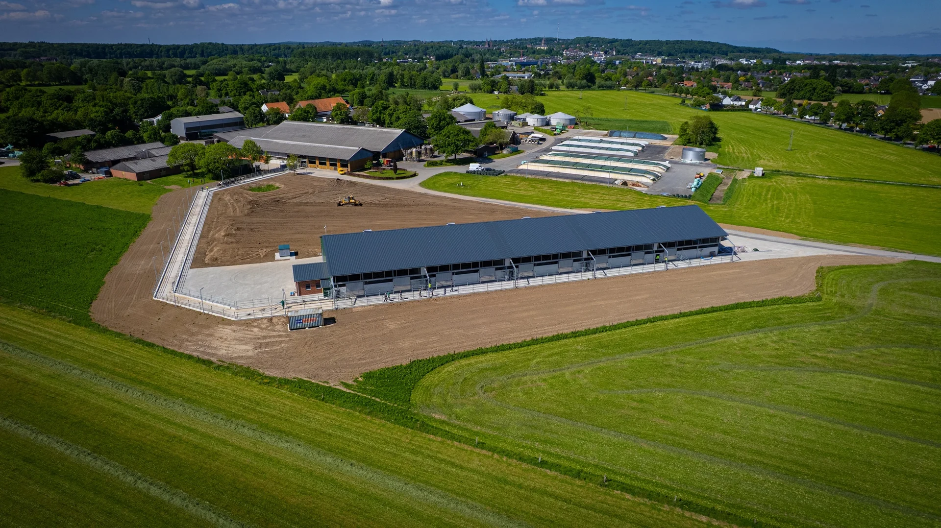 Eine Wissenschaftlerin und ein Wissenschaftler arbeiten hinter einer Glasfassade und mischen Chemikalien mit Großgeräten.