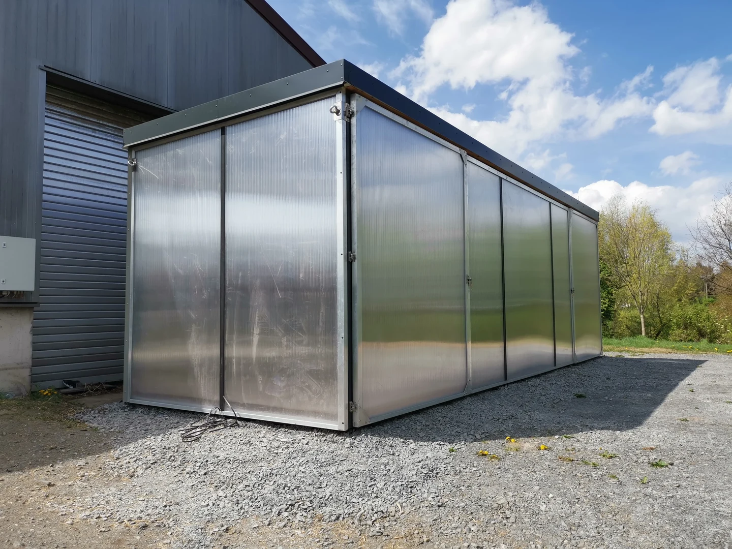 Eine Wissenschaftlerin und ein Wissenschaftler arbeiten hinter einer Glasfassade und mischen Chemikalien mit Großgeräten.